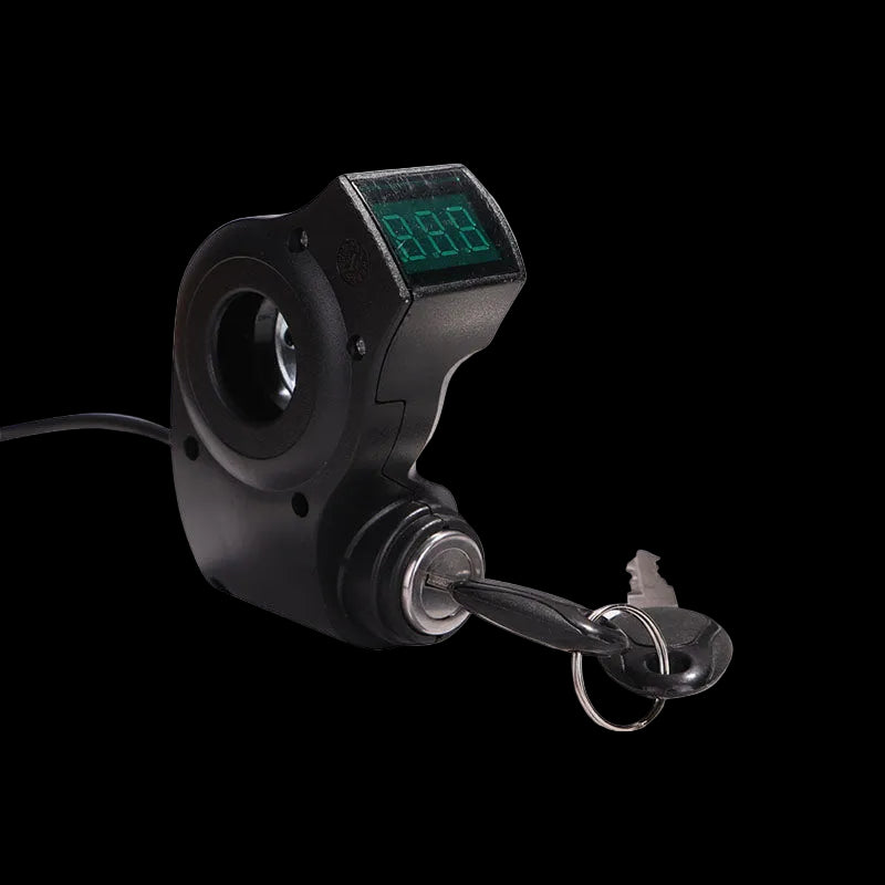 A black voltmeter electronic device with a small green digital display and attached key, shown on a solid black background.